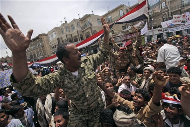 Yemeni army officers lifted by anti-government protestors shout slogans during a demonstration demanding the resignation of  of Yemeni President Ali Abdullah Saleh, in Sanaa, Yemen, Saturday, April 23, 2011. A sea of hundreds of thousands of anti-government protesters swelled along a five-lane boulevard reaching across Yemen's capital Friday in the largest of two months of demonstrations, as the government tried to halt military defections by arresting dozens of officers. (AP Photo/Muhammed Muheisen)
